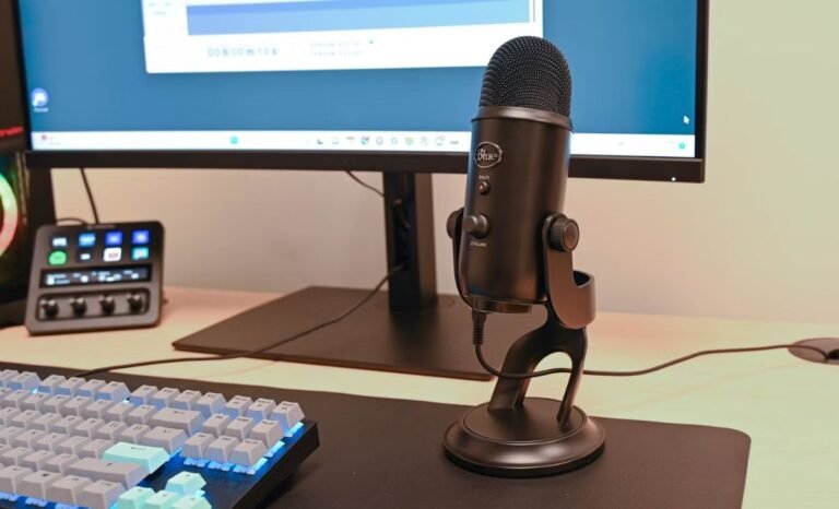 Desktop setup featuring a USB microphone on a stand, mechanical keyboard, and monitor, demonstrating the use of the Best mic software for PC for high-quality audio recording.